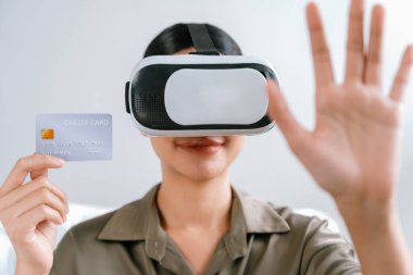 Sanal gerçeklik gözlüğü kullanan genç bir kadın online alışveriş deneyimi için evde. Sanal gerçeklik VR yeniliği dijital eğlence yaşam tarzı için optimize edildi.
