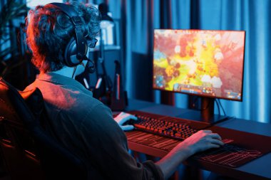 Savaş arenasında çoklu oyunlar takımıyla Moba 'da savaşan genç oyun flamasının sunucu kanalı, neon dijital ışık modern odasındaki arka görüntü ile bilgisayar monitöründe kulaklık takıyor. Toplayıcı.