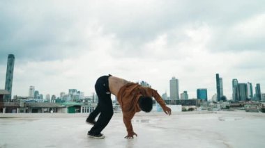 B-boy dans gösterisi çatıda sokak dansçısı ve gökyüzü dövüşçüsü, şehir manzaralı. Çekici Asyalı hipster enerjik adımlar atıyor. Break dansçı sokak dansı. Açık hava sporu 2024 hiphop..