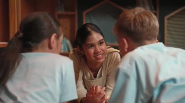 Kafkasyalı bir kız kütüphanede çok kültürlü bir arkadaşıyla kitap okurken aynı deneyimi paylaşıyor. Bir grup mutlu öğrenci kitaptan İngilizce öğrenirken ya da okurken konuşuyor. Öğretim