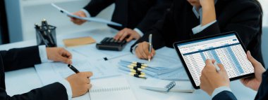 Şirket muhasebeci takımı, mali verilere dayanarak vergi iadelerini hesaplamak ve azami düzeyde tutmak ve finansal performansı artırmak için tablet üzerinde muhasebe yazılımı kullanır. Modern iş muhasebe konsepti. Kurnaz.