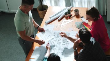 Proje yöneticisi çalışırken ve kahve içerken iç mimari planlama binasının üst görüntüsü. Bir grup mühendis fikir üretiyor ve fikir sunarken ev yapısını tasarlıyor. Sempozyum.