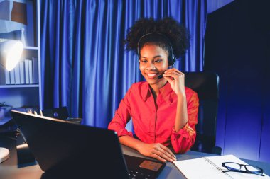 Güzel Afrikalı Amerikalı danışman, müşteriyle konuşuyor. Kulaklıklarla telefon görüşmesinde sorunu çözmek için. Yaşam koçu danışmanı çevrimiçi sosyal medya konusunda tavsiye veriyor. Tatlandırıcı.