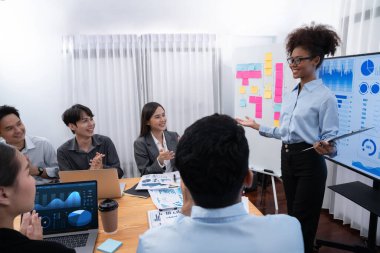 Genç Afrikalı iş kadını modern toplantıda TV ekranında veri analizi paneli sunuyor. Bir grup iş adamıyla konferans odasında iş sunumu. Uyum