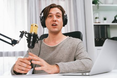 Sunucu kanalı, gülümseyen akıllı yayıncı kaydı, senaryosu ve akıllı telefonuyla sosyal medyada sohbet programı, kulaklık takarak modern ev stüdyosundaki video flamalarını kaydediyor. Bireysel.