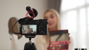 Güzellik ve kozmetik öğretim videosu içeriği yapan kamera görüntüsü kadını ya da perde arkası görüntüsü. Güzellik blogcusu izleyicilere ya da sosyal medya takipçilerine güzellik hizmetinin nasıl uygulanacağını gösteriyor. Blithe