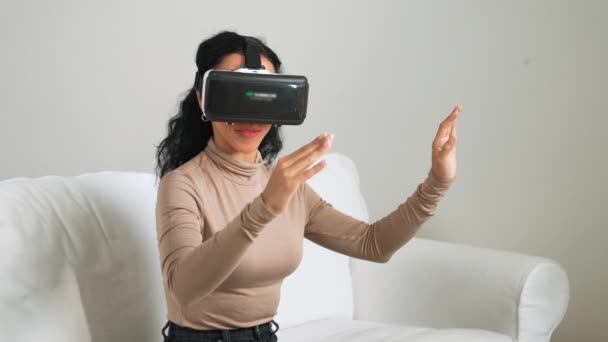 Ung Kvinna Använder Virtuell Verklighet Goggle Hemma För Avgörande Online — Stockvideo