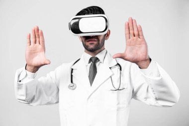 Tıbbi form tutarken VR gözlük ve laboratuvar önlüğü takan profesyonel bir doktor. Metastaz ya da sanal gerçeklik dünyasını hastalarla konuşmak ve onları iyileştirmek için kullanırken şekle bakan çekici bir doktor. Sapma.