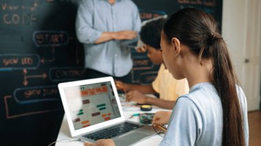 Öğretmenler kodlama sistemini öğretirken, farklı akademik öğrenciler STEM teknoloji sınıfında ana tahtayı dizüstü bilgisayar programlama programlama komut veya mühendislik koduyla düzeltiyorlar. Öğretim.