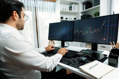 Akıllı tüccar işadamı, modern merkez ofisindeki araştırma pazarında en yüksek kârlı finansal teknolojiye yatırım yaparak bilgisayar üzerinde iki dinamik borsa yatırım ekranını analiz ediyor. Tahmin et..