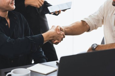 Çeşitli ofis çalışanları stratejik iş pazarlama toplantısı üzerine anlaşma yaptıktan sonra el sıkışıyor. Takım çalışması ve olumlu tutum verimli ve destekleyici bir iş yeri yaratır. Tedbirli