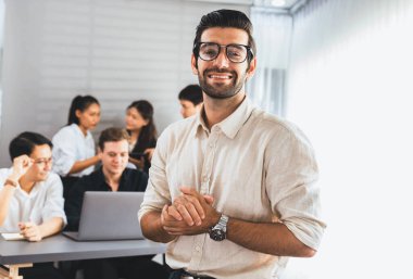 Ofiste çalışan iş arkadaşı ve iş adamlarının geçmişine sahip özgüven ve mutlu gülümseyen iş adamı portresi. Ofis çalışanı takım çalışması ve pozitif iş yeri konsepti. Tedbirli