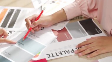 Grafik tasarımı için renk seçimi yapan ve beyin fırtınası yapan iki tasarımcının yavaş çekim çekimi ya da tasarım bürosunda kromatik danışmanlık hizmeti isteyen bir müşteri. Değiştirilmiş