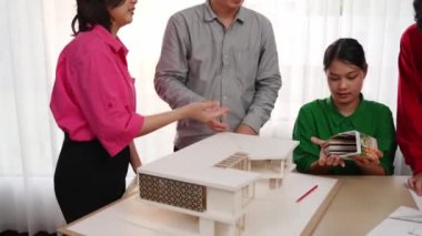 Ev tasarımcısı mimari ekipman kullanarak bir plan çizerken, iç tasarımcı da müşterilerin talebine göre renk örneklerinden uygun renkler seçiyor. Değiştirilmiş