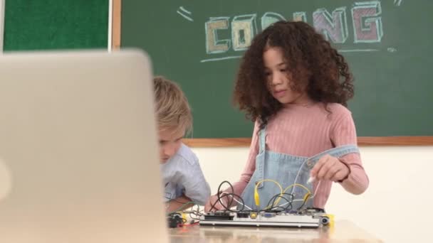 聪明的女孩站在那里用螺丝刀修理电板 快乐的学生和快乐的高加索男孩一起工作检查电力系统 好奇的孩子在船上工作 教育学 — 图库视频影像