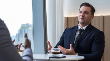 Şehir manzaralı bir süs ofisi, işletme fakültesi ya da MBA öğrencisi kahve molasında kariyer yollarını tartışıyor. Şirket danışmanı iş görüşü ve müşteri fikri.