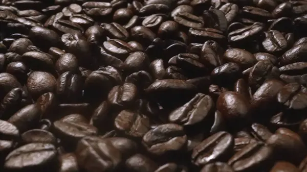 宏观拍摄的超级慢镜头新鲜咖啡豆置于黑色背景 围绕着一堆堆芳香的烘焙咖啡种子 宏观地理学豆类散落各处 可赔偿性 — 图库照片