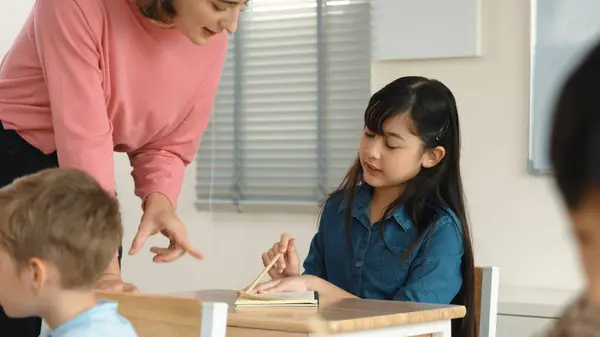 Asian Girl Writing Taking Note While Teacher Checking Classwork Caucasian — Stock Photo, Image