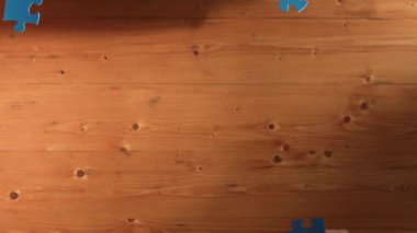 Yetenekli iş adamlarının yukarıdan görünüşü mavi yapbozu toplantı masasında monte ediyor. Çeşitli takımlar bulmacayı çözmek için birlikte çalışıyor. Beraberliği temsil eden, işbirlikçi. Cemaat.