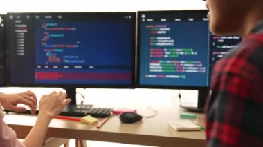 Yavaş çekim arkası yazılım geliştirici mühendisi bilgisayar programlama için birlikte çalışarak hata ayıklama kodunu çözüyor, ofiste monitörde karmaşık algoritmaları çözüyor. Filizlenen