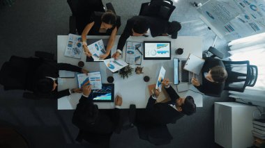 Çeşitli pazarlama ekipleri iş toplantısına hazırlanıyor. İş adamlarının yukarıdan aşağıya havadan görüşü masaya dizilmiş dizüstü bilgisayar ve tablet ile mali istatistikler. Yaratıcı iş. Müdürlük.