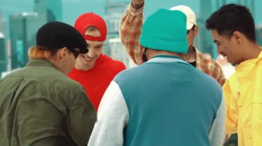 Çeşit çeşit hipster, şehir manzaralı çatıda dans ederken şık kıyafetler giyer. Break dansçı grup atlayışı, ellerini çırp ve partide müziğe geç. Açık hava sporu 2024 hiphop..