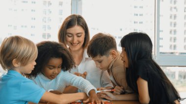 Masada masal kitabı ve renkli kitapla otururken çeşitli öğrencilere hikaye anlatan profesyonel beyaz bir öğretmen. Eğitmenden renkli resim alırken akıllı öğrenci dinlemeyi öğrenir. Etkinlik.