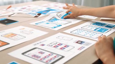 Mobil uygulama için kullanıcı arayüzü prototipi ya da masadaki program modeliyle birlikte web sitesi planlaması yapan bir şirket çalışanı. UX UI tasarımcısı kullanıcı dostu arayüz planını dikkate alır. Sinerjik