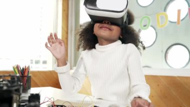 Meta-evrende öğrenmek için VR kulaklık takan yaratıcı kız. Komik çocuk yapay zeka kulaklığı takıp BTMM teknoloji sınıfında sanal dünya programına katılmayı seviyor. Yenilik. Gelecekteki yaşam tarzı. Etkinlik.