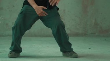 Kulaklıktan çimento arka planda müzik dinlerken break dans pratiği yapan yakışıklı bir hippi. Yakışıklı Asyalı sokak dansçısı robot dansı yapıyor. Açık hava sporu 2024. Modern dans. hiphop.