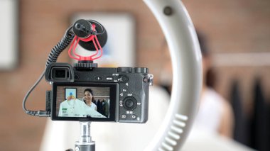 Arka görünüm, kamera ekranında kadın nüfuzunu gizler. Video görüntüleme, video görüntüleme, giysi, sosyal medya ya da blog. Canlı yayın için canlı stüdyo ışıklandırması olan kız canlı yayın pazarlama kaydı