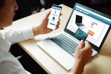 Genç adam, laptop bilgisayar başvurusu ya da web sitesinde online alışveriş yapmak için kredi kartı kullanıyor. E-ticaret ve online alışveriş konsepti. uds