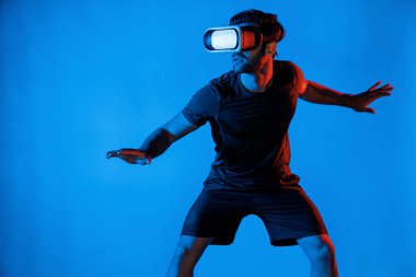 Hizmet ederken VR kulaklık takan adam metaverse 'e giriyor. Teknoloji yenilik gözlüğü kullanan profesyonel sporcu. Vücudu neon ışıklı arka planla dengeliyor. Sapma.