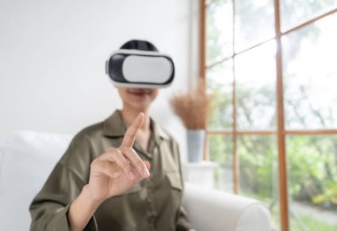 Sanal gerçeklik gözlüğü kullanan genç bir kadın online alışveriş deneyimi için evde. Sanal gerçeklik VR yeniliği dijital eğlence yaşam tarzı için optimize edildi.