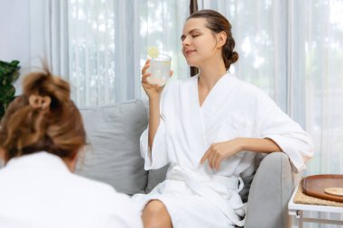 Güzellik ya da vücut bakımı güzellik salonu yaşam tarzı konsepti. Bornoz giyen bir kadın lüks otel kaplıcalarında ya da tatil odasında içkiyle rahatlıyor. Tatil ve boş zaman rahatlığı. Sessiz.