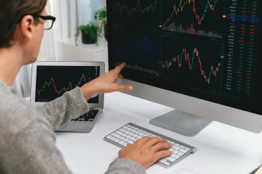 Akıllı yatırımcılar bilgisayar ekranlı ilginç borsa takasını işaret ediyorlar. Finansal teknoloji dinamik yatırım planı modern işyerindeki veri grafiğine odaklanıyor. Bireysel.