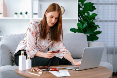 Genç mutlu kadın internetten alışveriş yaparak ürün satın alırken aynı zamanda internet üzerinden online ödeme sistemi ile çevrimiçi mağaza platformundan en yüksek siber güvenlik tarafından korunan ürünler sipariş ediyor.