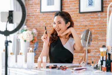 Kadın Etkilenen Vlog video görüntülerini canlı olarak çekiyor. Makyajın çoğu sosyal medya ya da blog 'u anlatıyor. Kozmetik stüdyosu ışıklandırmalı mutlu genç kız çevrimiçi pazarlama oturumu yayını için..