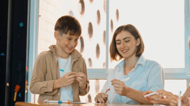 Çizim kitabında işaret kullanarak çeşitli öğrencilerin ve zeki öğretmen çizimlerinin panorama çekimi. Sanat dersinde çizim kitabını kullanarak çok kültürlü bir öğrenci. Rahatlama. Etkinlik.