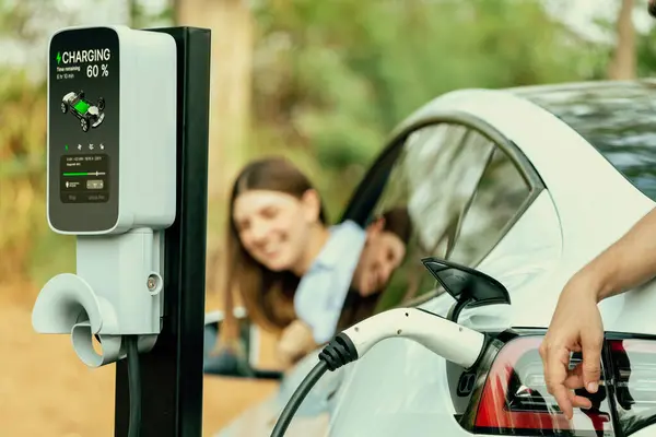 Прекрасна Молода Пара Заряджає Батарею Електромобіля Під Час Автономної Подорожі — стокове фото