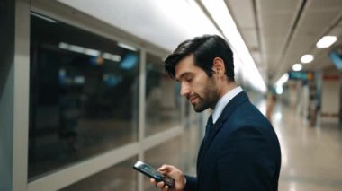 Profesyonel iş adamı tren istasyonunda dikilirken kameraya gülümser. Beyaz yetenekli yönetici kameraya bakarken kendine güvenen bulanık bir geçmişi var. Sevinçli..