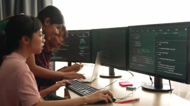 Yavaş çekim arkası yazılım geliştirici mühendisi bilgisayar programlama için birlikte çalışarak hata ayıklama kodunu çözüyor, ofiste monitörde karmaşık algoritmaları çözüyor. Filizlenen