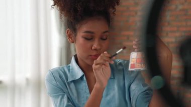 Kadın nüfuzlu kişi canlı yayında video görüntülerini çekiyor. Makyaj çok önemli sosyal medya ya da blog. Kozmetik stüdyosu ışıklandırmalı mutlu genç kız çevrimiçi pazarlama oturumu yayını için..