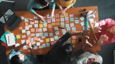 Akıllı proje yöneticisinin konuşmasının ve fikir ve alkışlamayı açıklamasının üst görüşü. İş dünyasının havadan görünüşü başarılı projeyi alkışlıyor. Toplantı odasında el çırpma takımının hava görüntüsü. Sempozyum.