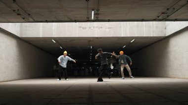 Panorama 'da hipster grup dansı yaparken B-boy dansı yapıyorduk. Sokak dansçısı takımı dondurucu poz verirken hip hop müziğine geçiyor. Break dans, sokak dansı. Açık hava sporu 2024. Yumuşak bir şekilde..