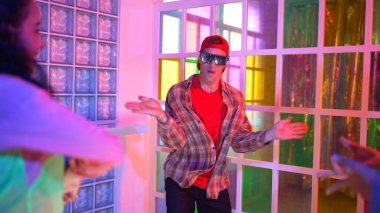 Kafkas dansçısı dans ederken çeşitli arkadaşları gece kulübünde neon ışıkta ayak seslerine bakıyor. Çoklu etnik kökenli hipsterin serbest stil müziğe geçişi ve mutlu bir adamın kameraya bakışıyla. Mutluluk.