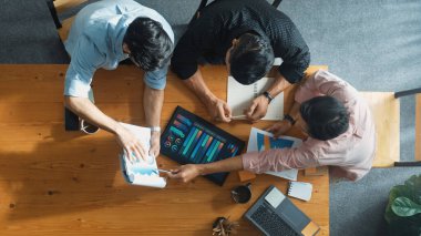 Yönetici, toplantı odasındaki meslektaşlarına mali grafiği açıklar. Farklı pazarlama ekibinin tabletle masada otururken fikir ve planlama stratejisini en üst düzeyde paylaşması. Cemaat.