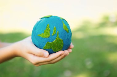 Dünya gezegenini ESG ilkesi ve çevre dostu enerjisiyle daha parlak bir gelecek için Dünya günü olarak el ele tutuşan genç çocuklar. Döngü