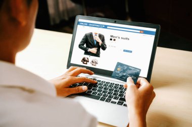 Genç adam, laptop bilgisayar başvurusu ya da web sitesinde online alışveriş yapmak için kredi kartı kullanıyor. E-ticaret ve online alışveriş konsepti. uds