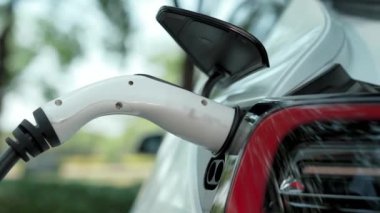 EV elektrikli araç EV şarj istasyonu ulusal park veya açık hava orman manzaralı. Çevre dostu EV arabalarla yaz ormanlarında doğal koruma. Yükselt